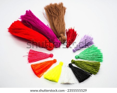A group or cluster of tassels consisting of wool, silk, thread, or the like, usually used for hanging.