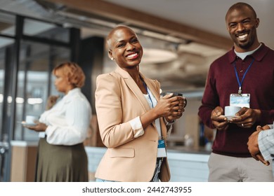 Group of colleagues are sharing a light-hearted moment during a coffee break. They're engaged in casual conversation, exuding a warm, friendly atmosphere in a contemporary office setting - Powered by Shutterstock