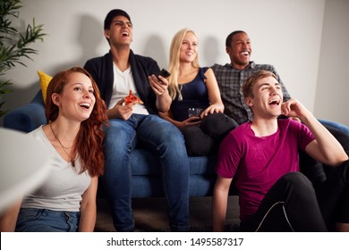 Group Of College Friends Celebrating Whilst Watching Sports Game On TV In Shared House