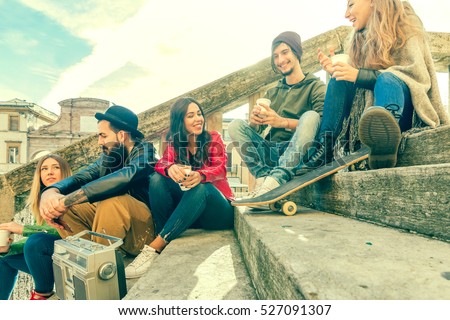 group of college friends gathering having fun chatting sitting on stairs outdoors. happy youngsters meeting outdoors. concept youth freedom togetherness joy and sharing. retro color tones