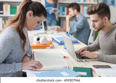 Group Of College Students Doing Homework And Studying Together, They Are Using Laptops, High Tech Classrooms And Innovation Concept