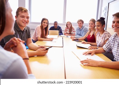 Group Of College Students Sitting At Table Having Discussion