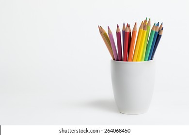 A group of color pencils in a white cup on an isolated background - Powered by Shutterstock