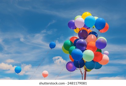A group of colorful balloons outside on a cloudy day
