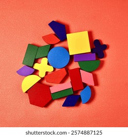 Group of colorful basic and random shapes isolated on square pink colored background from top angle view.