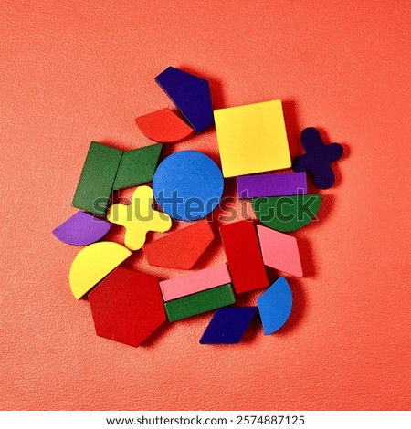 Group of colorful basic and random shapes isolated on square pink colored background from top angle view.