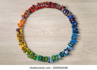 Group Colorful Childish Car Toy Hot Wheels In Accuracy Circle On Wooden Floor Top View. Collection Of Modern Miniature Automobile Playthings, Many Sport Vehicle Model Transport For Hobby And Leisure