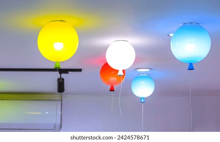 Group of colorful illuminated lighting of round ceiling lamps in balloon shape decorative inside of white living room, home interior decoration concept - Powered by Shutterstock