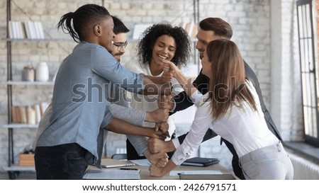Group of company employees having fun in team building meeting. Smiling business coach engaging office workers in ice breaker activities. Professional team leader teaching workers to be team players