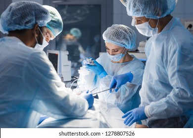 Group Of Concentrated Surgeons Engaging In Rescue Of Male Patient In Operation Room At Hospital, Emergency Case, Surgery, Medical Technology, Health Care And Disease Treatment Concept