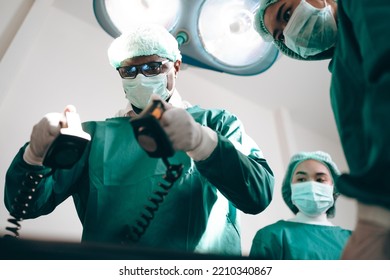 Group Of Concentrated Surgeons Team Engaging In Rescue Of Male Patient In Hospital Operation Room, Emergency Case Of Surgery Medical Technology, Health Care And Disease Treatment Concept