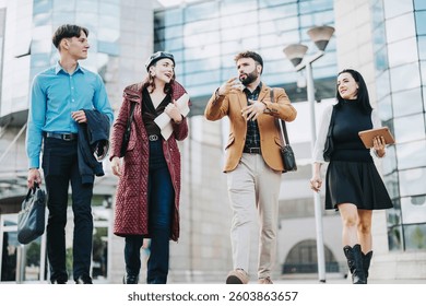 A group of confident business professionals walking outdoors, discussing ideas. The modern glass building backdrop highlights a vibrant, urban setting perfect for corporate activities and teamwork.