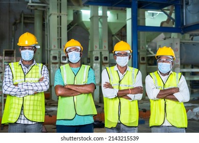 Group Of Confidently Standing Industrial Workers With Arms Crossed By Looking At Camera At Workplace - Concept Of Workforce, Occupation, Blue Collar Jobs And Safety