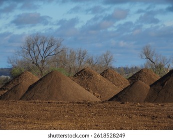 A group of conical earth soil tailing piles in a field near Tring, in Hertfordshire, England.