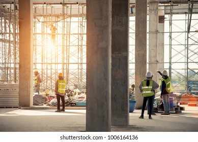 Group of construction engineer team in standard safety uniform work planing in construction site - Shutterstock ID 1006164136