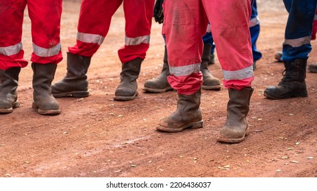 Group Of An Construction Workers With Fully PPE Are Standing On Dirt Route At Working Site During Safety Meeting. Selective Focus At Safety Shoe Part.