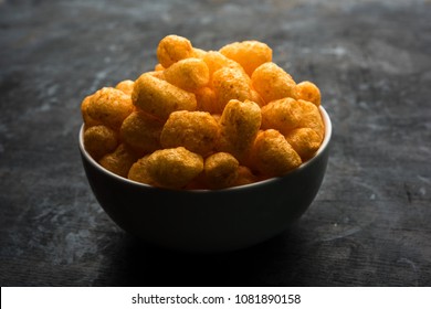 Group of Corn Puff, cheese balls and rings, crispy salty Wheel fryums, puffed rice and potato in macaroni shape with plain/spinach flavour, chatpata masala and crunchy fried snacks served in bowls 