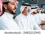 Group of corporate arab businessmen meeting in the office - Middle-eastern businesspeople wearing emirati kandora working in a meeting room, Dubai