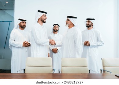 Group of corporate arab businessmen meeting in the office - Middle-eastern businesspeople wearing emirati kandora working in a meeting room, Dubai - Powered by Shutterstock