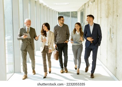 Group of corporate business professionals walking through office corridor on a sunny day - Powered by Shutterstock