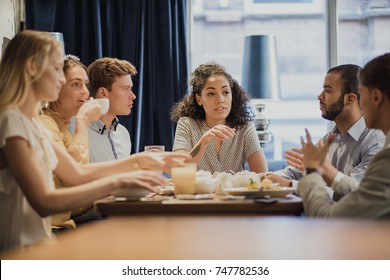 Group Of Coworkers Are Having A Meeting While Enjoying Breakfast In A Restaurant. 