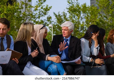 Group Of Coworkers Reviewing Content Outdoors