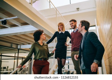 Group Of Coworkers Walking Down The Stairs , Talking