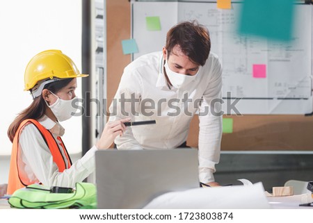 Group of creative building architect construction engineer project meeting and brainstorm together. Industry, Engineer, construction concept. Members wear face mask prevent covid-19 virus