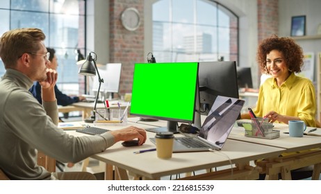 Group of Creative Colleagues Working on Computers in a Modern Bright Office. Male Administrator Preparing a Presentation Using Green Screen. Biracial Businesswoman Smiling. - Powered by Shutterstock