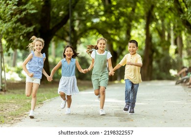 Group of cute asian and caucasian kids having fun in the park - Powered by Shutterstock