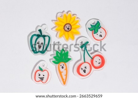 Group of cute shrink paper solid diy colorful charm crafts object with vegetable and fruits shape isolated on horizontal white colored background.