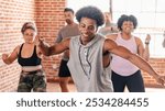 Group dance class with diverse participants enjoying exercise. Smiling individuals in a bright studio, moving energetically in a fun dance workout. Diverse people exercising in fitness class.