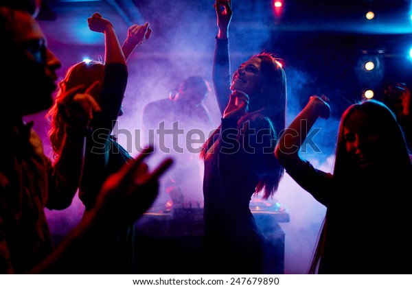 Group of\
dancing young people enjoying night in\
club