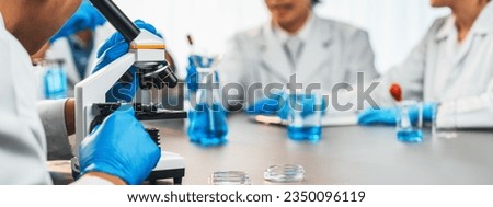 Group of dedicated scientist conduct chemical experiment using microscope in medical laboratory to develop new vaccine drug or antibiotic. Biotechnology lab and medicine research concept. Neoteric 商業照片 © 