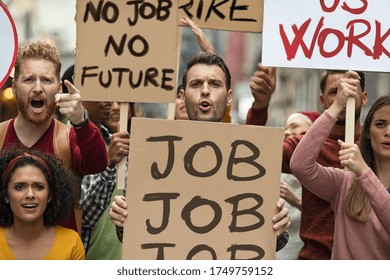 Group of demonstrators with banners protest for job and equal salaries. Protestors people holding signs and posters strike for unemployment. Group of multiethnic men and women protesting with placards