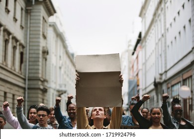 Group of demonstrators with blank banner protesting on the street. Protestors on the street holding sign boards.