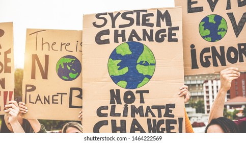 Group of demonstrators on road, young people from different culture and race fight for climate change - Global warming and enviroment concept - Focus on banners - Shutterstock ID 1464222569