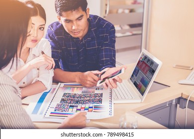 group of designer working graphic on computer with color chart and write short note for choose a color