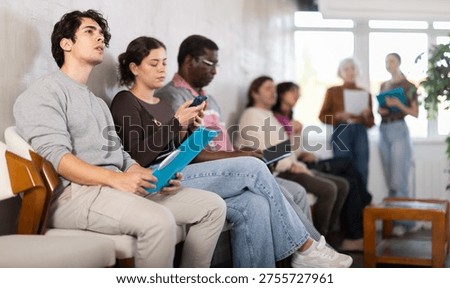 Group of of different ages in the office while waiting for an interview. Specialists, men and women in search of job are waiting for an interview in a prestigious company