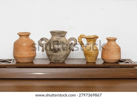 Group of different rustic Mexican terracotta vases of various shapes and sizes on a wooden stand, rustic decoration in a country house, Mexican handicraft in antique style