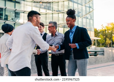 A Group Of Diverse Business People Are Greeting Each Other In The Street  By Shaking Hands