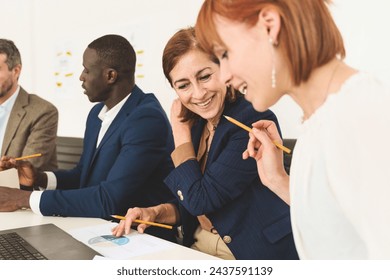 Group of diverse business team discussing project plans in office setting - cooperation and strategy - Powered by Shutterstock