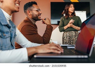 Group of diverse businesspeople having a meeting in a boardroom. Young businesspeople smiling happily during a discussion. Multiethnic businesspeople working together as a team. - Shutterstock ID 2151535935