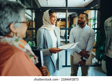 Group Of Diverse Businesspeople Holding A Staff Meeting In A Modern Office. Team Of Multicultural Entrepreneurs Running A Successful Startup In An Inclusive Workplace.