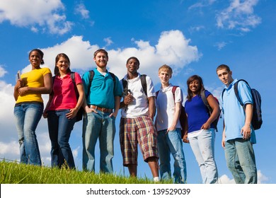 A Group Of Diverse College Students/friends Outside On A Hill With A Sky Background