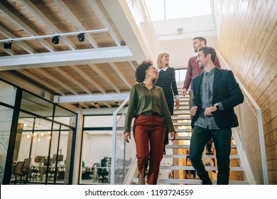 Group Of Diverse Coworkers Walking Down The Stairs In An Office