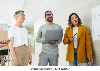 Group Of Diverse Designers Smiling Cheerfully During A Meeting In A Creative Office. Team Of Multicultural Businesspeople Collaborating On A New Innovative Project.