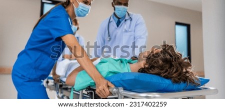 Group of diverse doctors moving seriously injured patient in hospital. Attractive professional medic surgeon people in a hurry move emergency patient lying on a stretcher into operating theater room. Foto stock © 