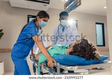 Group of diverse doctors moving seriously injured patient in hospital. Attractive professional medic surgeon people in a hurry move emergency patient lying on a stretcher into operating theater room. Foto stock © 