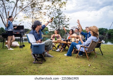 Group of diverse friend having outdoors camping party together in tent. Attractive young man and woman traveler drinking alcohol beer, enjoy hanging out during holiday vacation trip in wood forest. - Powered by Shutterstock